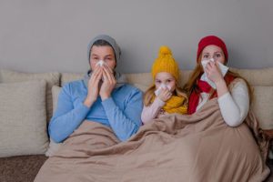 Sick family sitting on couch.