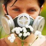 Woman holding flowers with gas mask.