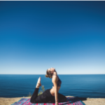 Woman in yoga pose near water.