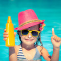 little girl in pool with sunscreen