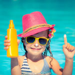 little girl in pool with sunscreen