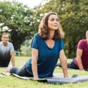 People doing yoga in the park.