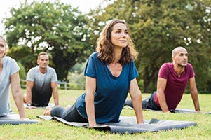 People doing yoga in the park.