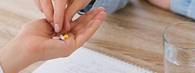 Health Professional Handing Pills to Patient