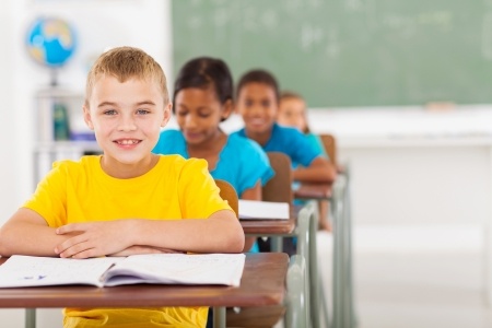 Boy Sitting in His Desk in Class