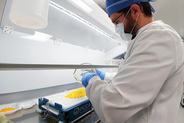 Coastal Move - Travis making capsules in the new compounding lab.