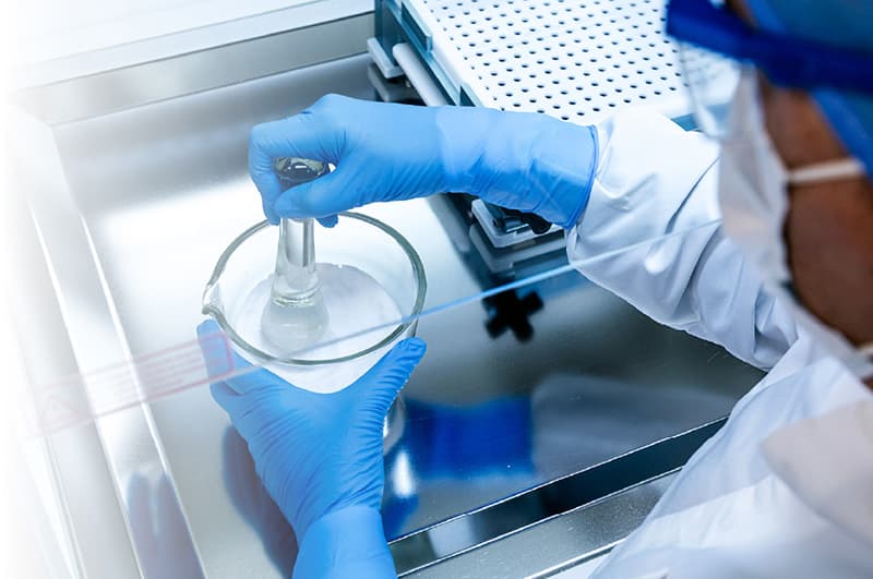 Pharmaceutical compounding: a technician preparing medication in a sterile environment.