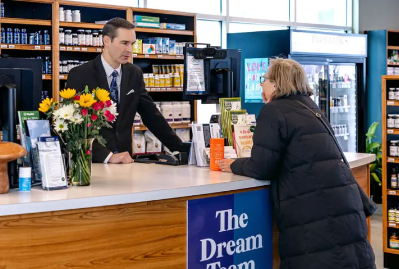 Joel speaking to a customer over the nutra counter .