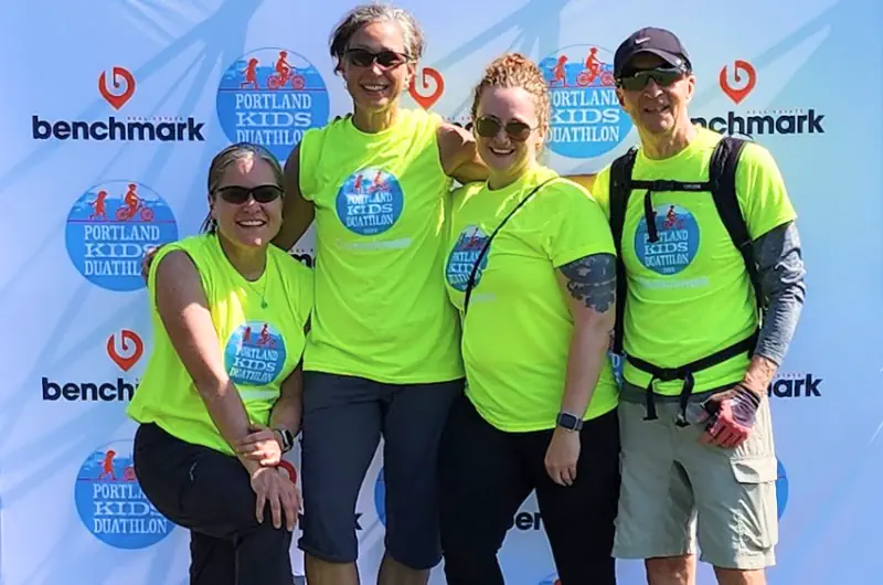 Coastal staff volunteers on top of Portland Kids Duathlon podium.