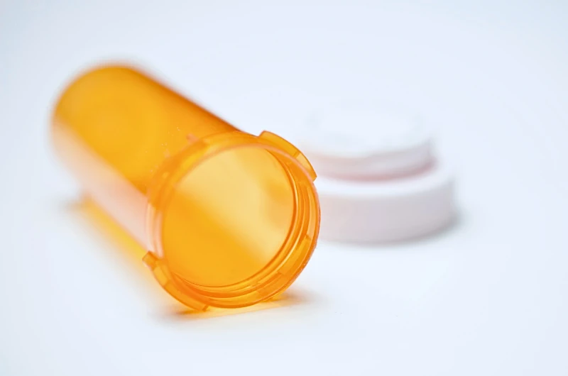 Empty prescription bottle laying on its side.