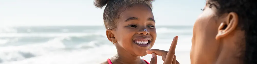 Woman applying sunscreen to a child's face